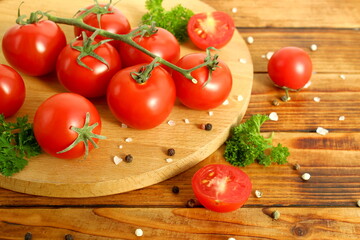 Cherry tomatoes branch lie on a wooden table