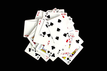 A deck of cards lies on a black background, scattered in one pile.