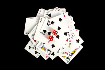 On a black background lies a deck of cards with dice.	