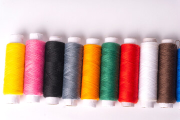 Colorful sewing thread set and needles isolated on background.
