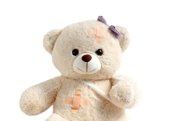 Teddy bear sits on a white background wounded.	