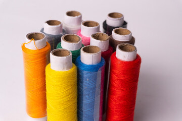 Colorful sewing thread set and needles isolated on background.
