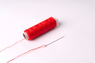 Colorful sewing thread set and needles isolated on background.
