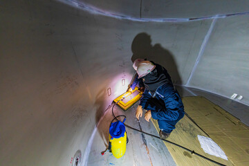 Male worker inspection vacuum test bottom plate stainless tank petrochemical steel weld