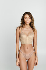 Fototapeta premium Young beautiful woman showcasing elegant lingerie style in chic setting
