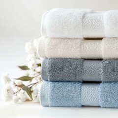 Luxurious Bath Towels: A stack of four plush, absorbent bath towels in a calming palette of white, beige, gray, and blue. Each towel is meticulously folded.