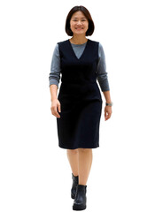 Fototapeta premium A woman with shoulder-length black hair walks confidently in a black dress, gray top, and black boots.