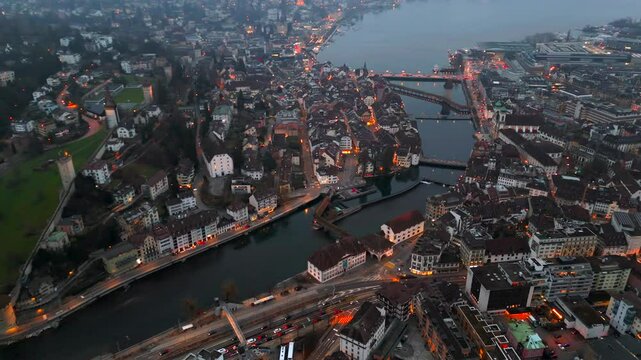 Stadtbild von Luzern Luftaufnahme, Schweiz bei Nacht mit Stadtlichtern, nebligem Wetter. Luftbild vom Fluss Reuss und allen bekannten Bruecken am Abend. Aerial view of city center of Lucerne at night