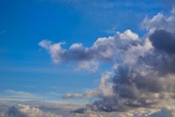 Dark clouds with soft sun highlights on their edges appear majestic and atmospheric. The depth and...