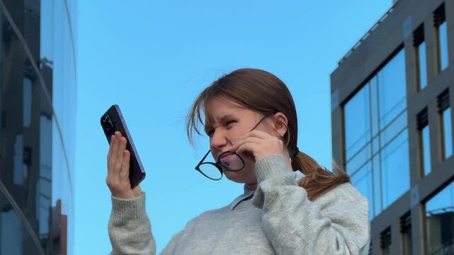 woman looking at phone and having trouble seeing, vision problem