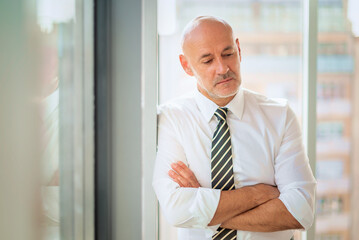 Fototapeta premium Mid aged man standing in front of a glass wall