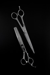 Two professional scissors on black background. Grooming and hair cut concept.
