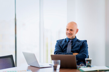 Businessman sitting at office desk and using his laptop for work