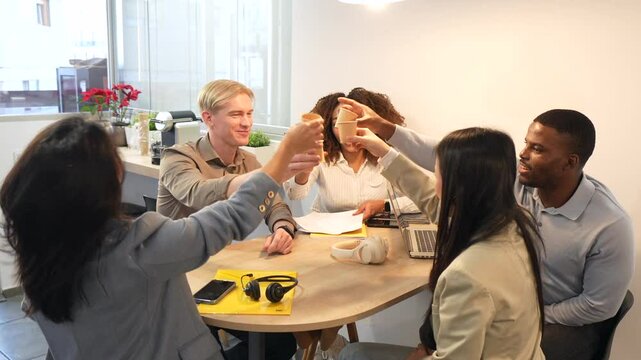 Coworkers toasting together in office break room