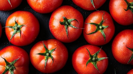 Brightly colored, ripe tomatoes rest on a dark surface, showcasing their natural sheen and fresh appearance. Ideal for highlighting wholesome ingredients and culinary creativity