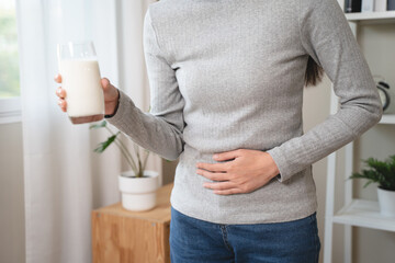 asian young woman having a stomachache, abdominal pain or digestive, hand in holding belly after...