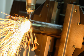 Close up scene the fiber laser cutting machine cut the stainless steel tube and sparkling light.
