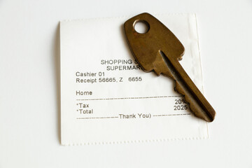 The shopping list includes the purchase of a home in the cash register receipt and the amount of 2025 and next to it lies the key to the house, buy a house