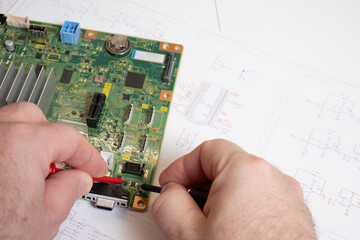 Engineer measuring circuit board voltage with probes
