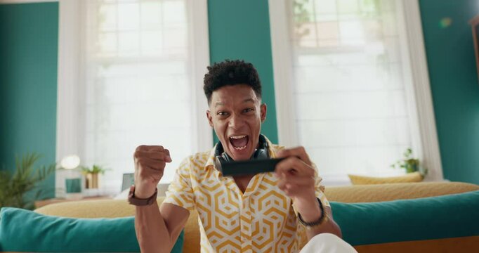 Gaming, winner and happy with man on sofa for success, streaming and esports subscription. Celebration, competition and virtual with person in living room at home for contest, pov or video games