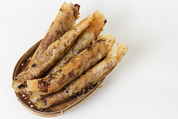 Close up of chocolate bananas or pisang cokelat in a woven bamboo container. isolated white...
