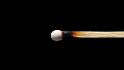 Close-up of burned matchstick against black background