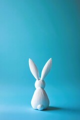 White, patterned rabbit turned around facing the bright blue background. Easter, trendy, copy space, minimalistic concept.