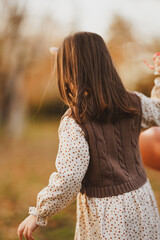 little girl playing in autumn park