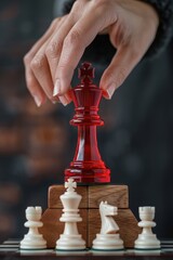 Woman puts a glossy red chess king figure on top of a pyramid, black background