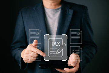 A businessman uses a digital tablet with a futuristic interface displaying TAX and related financial documents. This concept image represents taxation, inheritance, debt, and legal compliance.