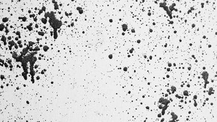 gray background, photograph of black paint splashes on white wall