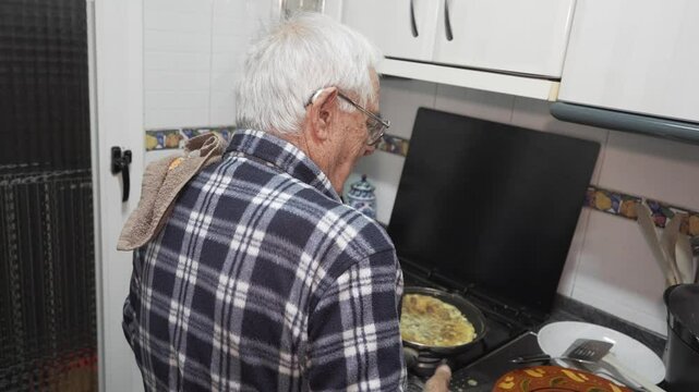 old man spinning vegetable omelette, eighty year old person in a checked shirt, living alone and cooking