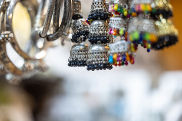 Traditional ethnic colorful silver earrings jewellery over blur background and copy space, Selective focus.	