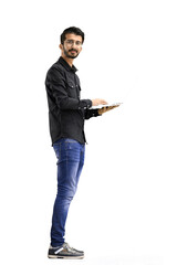 A man, on a white background, in full height, uses a laptop