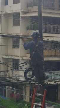 Un trabajador de la compa&ntilde;&iacute;a el&eacute;ctrica chuquea los cables de un poste de luz