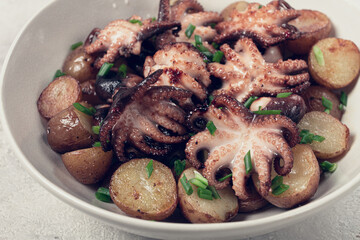 baby grilled octopus with golden baked potatoes and fresh herbs, Maltese cuisine, homemade, no people,