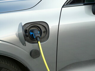 Electric car charging with a cable. A symbol of sustainable mobility, though range and charging...