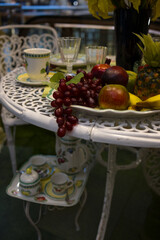 A festive table set with fruits and cups and saucers. Summer