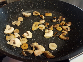 Mushrooms are fried in a pan. Food preparation process.