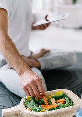 Unrecognizable man eating vegetable salad