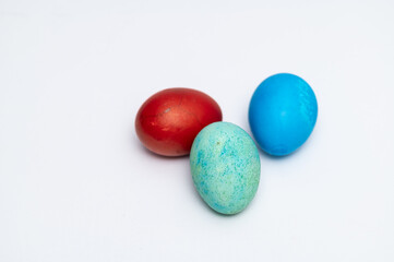 Colored red, blue and light green Easter eggs  on the white background  ready for Easter