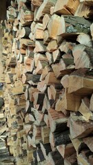 A close-up view of a neat stack of chopped firewood ready to burn, perfect for cozy winter nights.