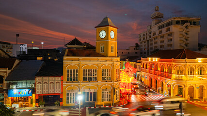 Naklejka premium Phuket,Thailand-February 10,2025: colorful sky above The classic building in Phuket. Scene of romantic beautiful sky sunset with cloud in the sky background. The clock tower is a landmark of Phuket.