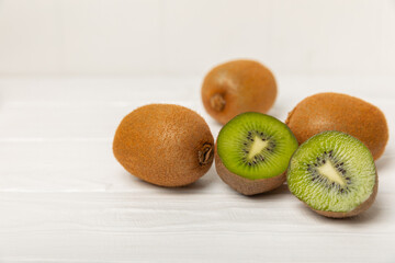 Kiwi on wooden background. Whole fruit and slices pieces of green kiwi on table. fresh ripe juicy...