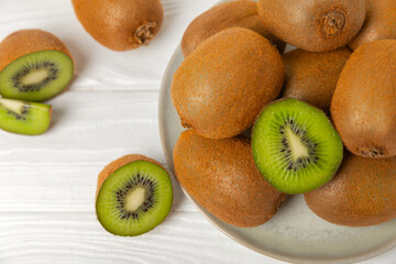 Kiwi on wooden background. Whole fruit and slices pieces of green kiwi on table. fresh ripe juicy...