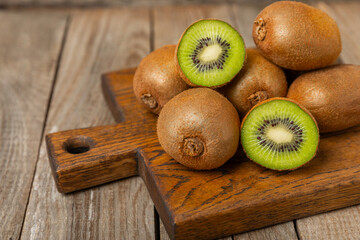Kiwi on wooden background. Whole fruit and slices pieces of green kiwi on table. fresh ripe juicy...