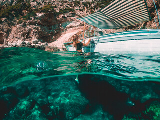 Woman swimming under water near a Boat