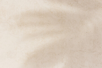 Soft shadows of tropical palm leaves on textured concrete background neutral beige colored. Summer travel, vacation, spa concept. Minimal style photography, summertime aesthetic backdrop copyspace