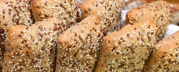 pieces of fresh wholemeal bread with sesame and flax seeds for sale in the artisan bakery