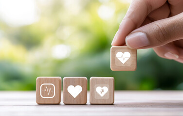 Hand placing wooden blocks with health symbols, representing health insurance concepts and wellness. This conveys importance of health and care in life